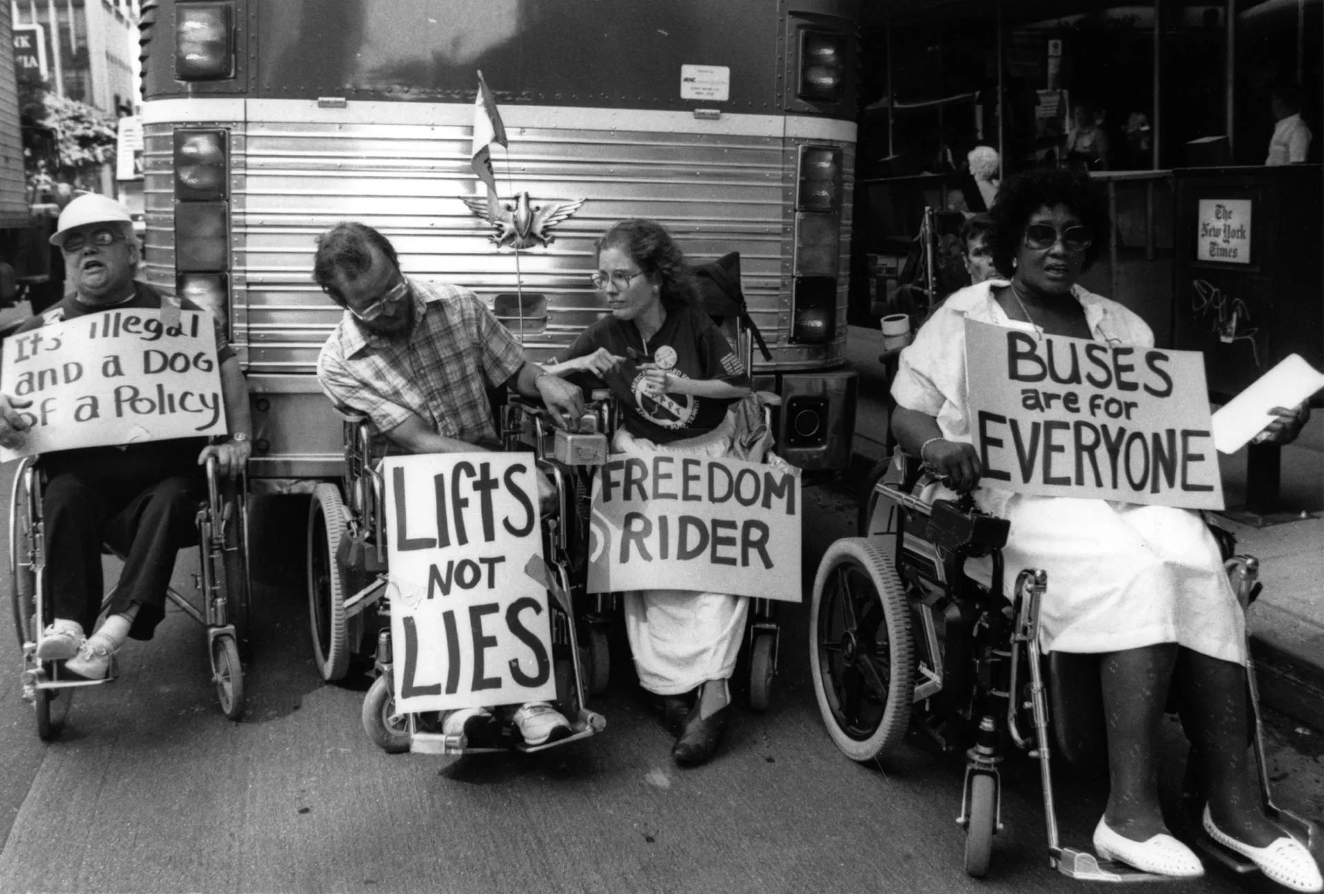Greyhound Bus Depot in Los Angeles, Diane Coleman, Steve Remington and Rick Wilson in their wheelchairs with protest signs in the street blocking a parked bus.
