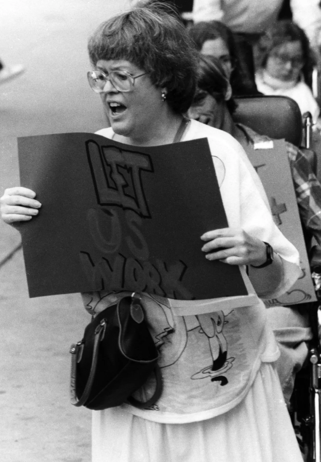 Christina Keeffer with a protest sign that reads “Let Us Work!”.